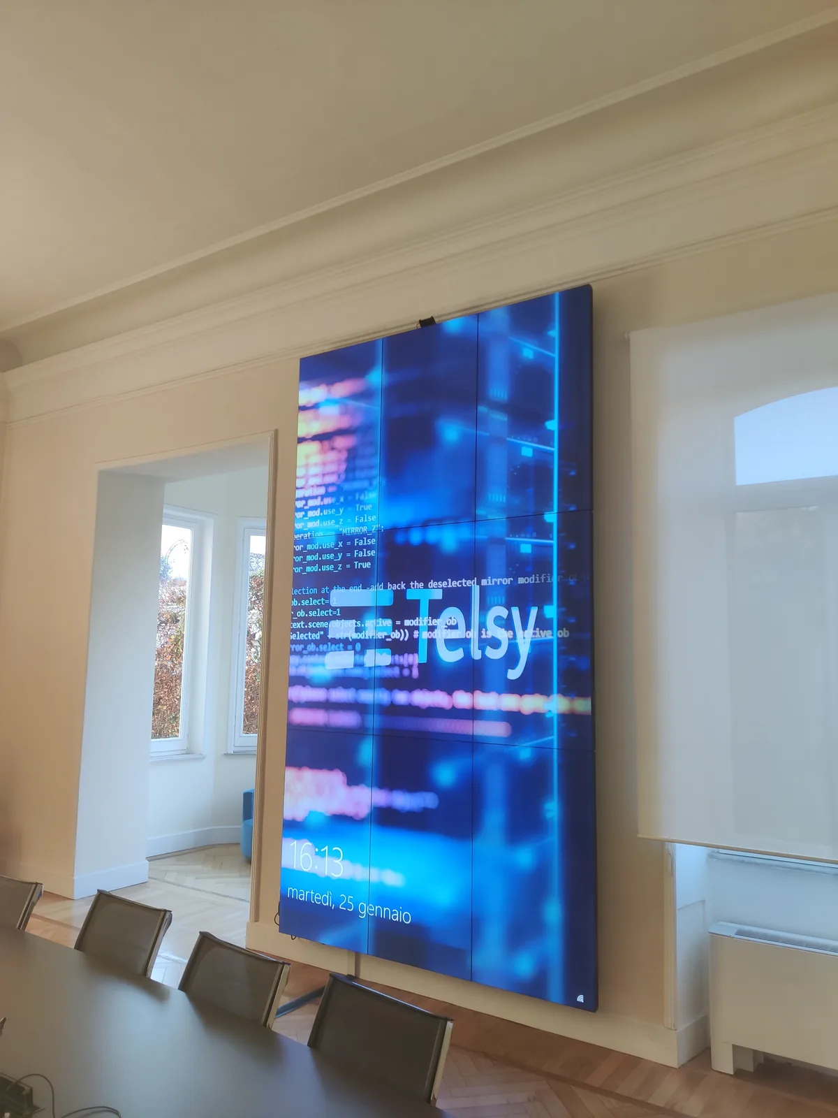 Videowall Sharp completato nella sala riunioni Telsy, con logo aziendale a schermo
